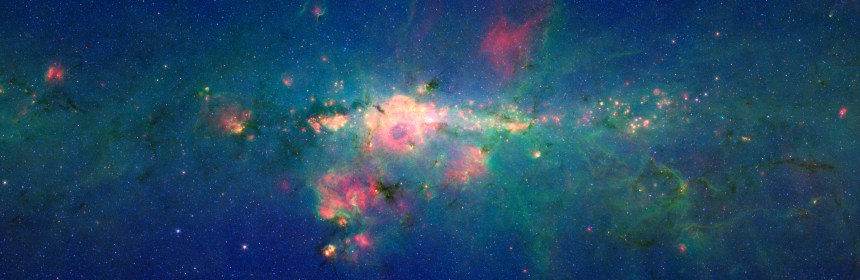 " The region around the center of our Milky Way galaxy glows colorfully in this new version of an image taken by NASA's Spitzer Space Telescope."