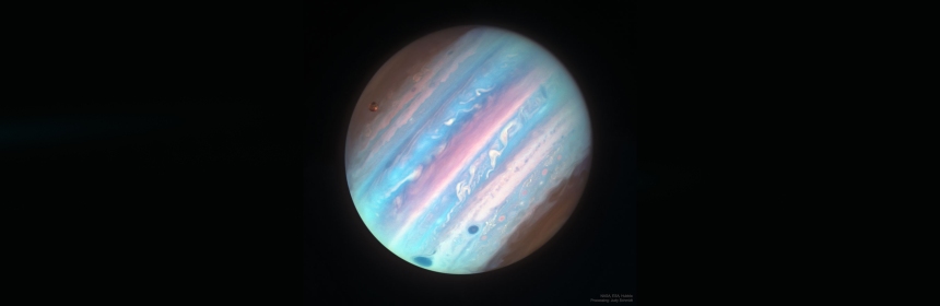 An image of the planet Jupiter in alternating blue and pink colors against a black backdrop.